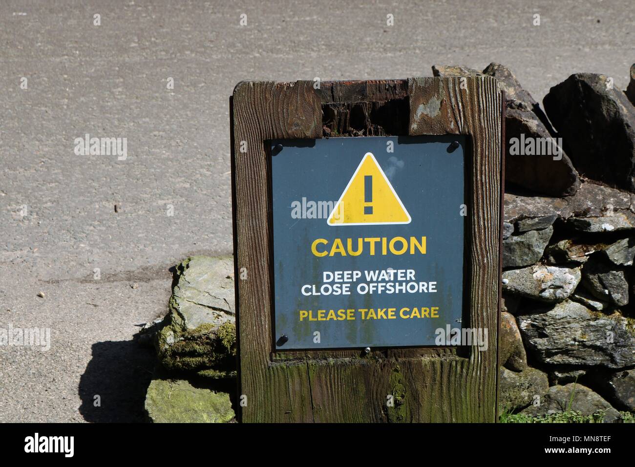 'Achtung tiefes Wasser in der Nähe Offshore Bitte achten Sie 'gelben und grauen Schild am Ufer des Loch Ness in Schottland, Großbritannien. Stockfoto