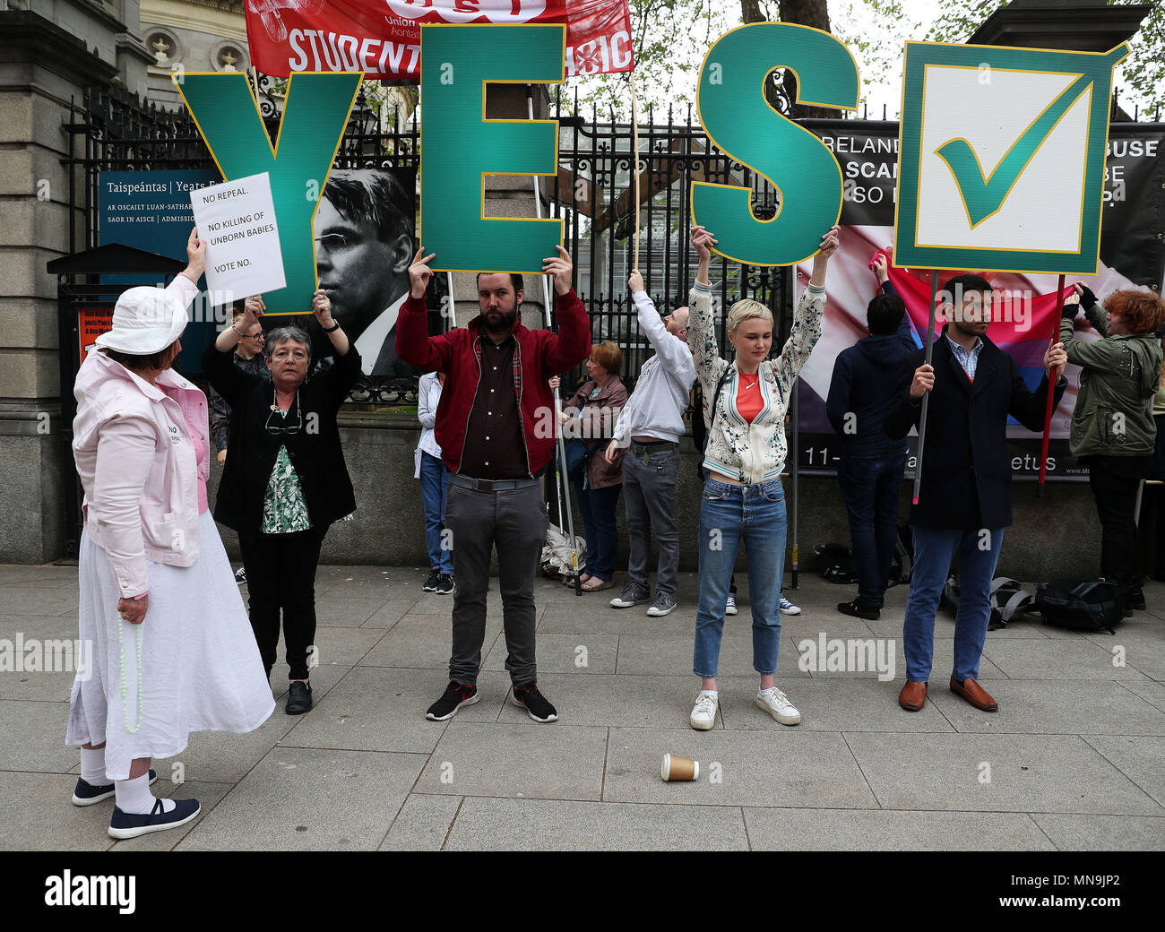 Ein anti-Abtreibung Spoiler ein Zeichen oben hält als pro-choice-Aktivisten Anti-abtreibungs-Banner, die Grafiken außerhalb Leinster House, Dublin enthalten, vor dem Referendum am 8. Änderung der irischen Verfassung am 25. Mai. Stockfoto