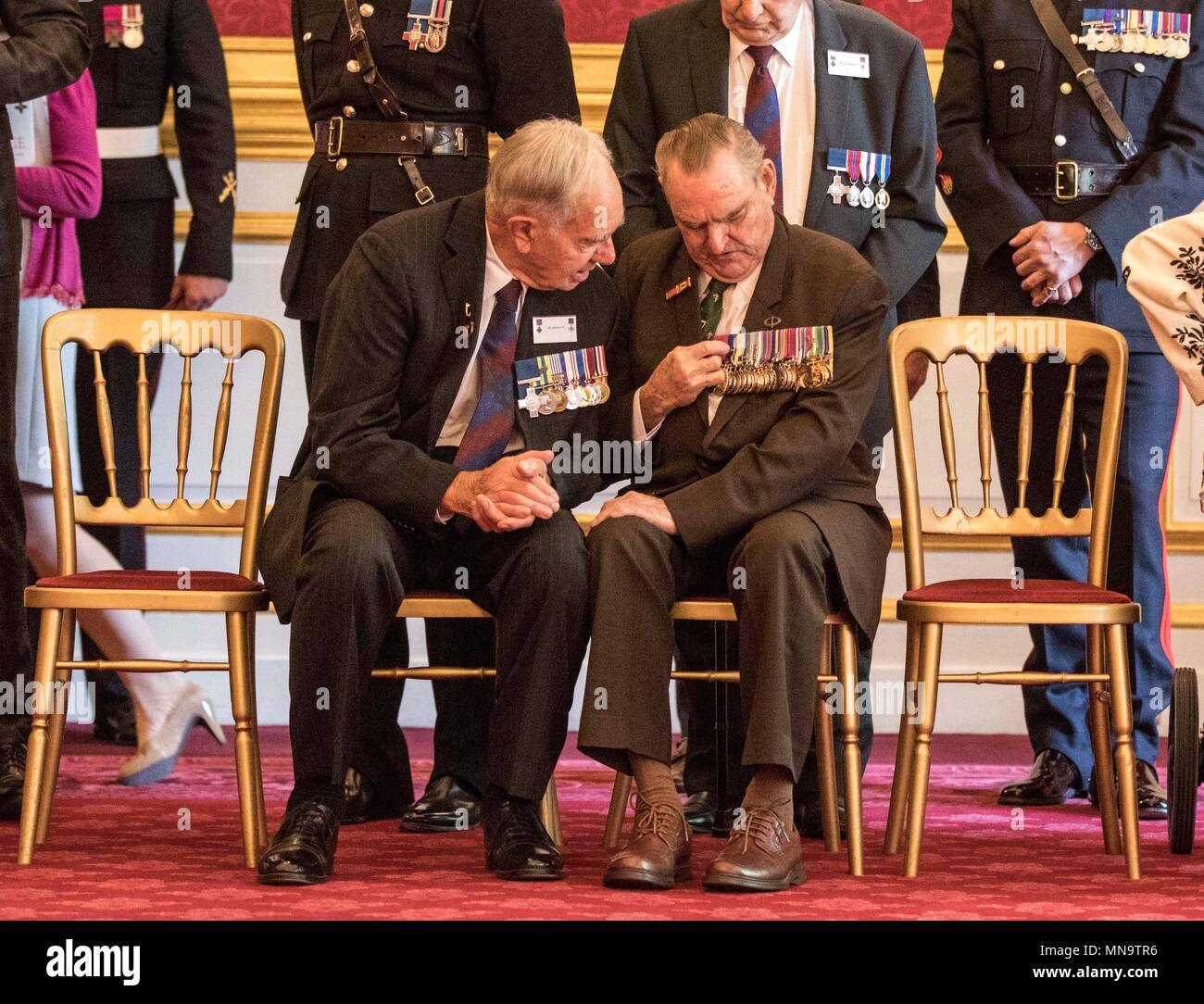 George Cross Empfänger Alf Lowe (links) betrachtet die Medaillen von Victoria Cross Empfänger Keith Payne während einer Tea Party im Clarence House in London für die Mitglieder der Victoria Cross und George Cross Association. Stockfoto