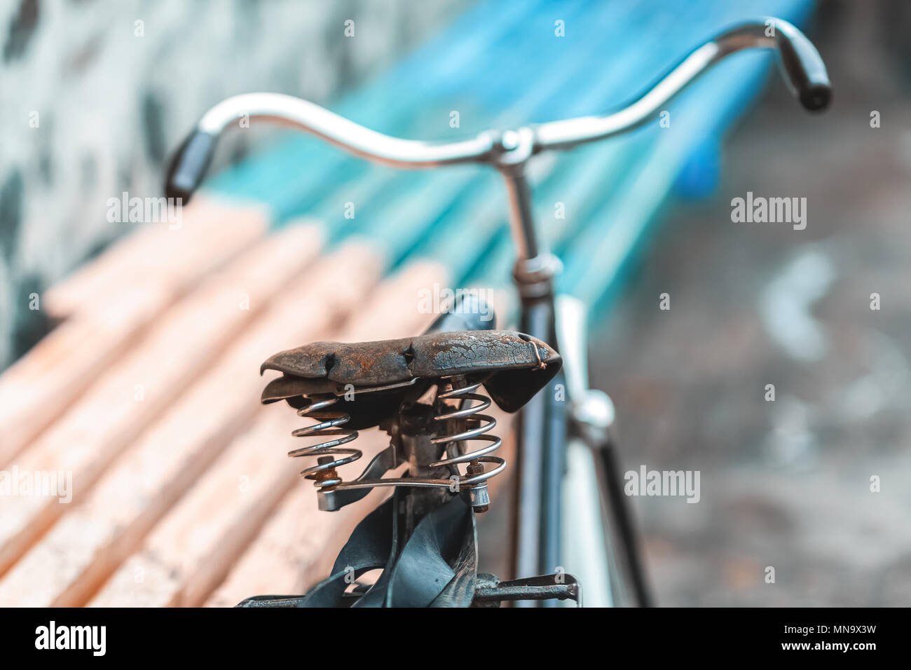Ein altes Fahrrad mit einer Feder Stoßdämpfer. Vintage Fahrrad auf der Steinmauer Hintergrund. Stockfoto