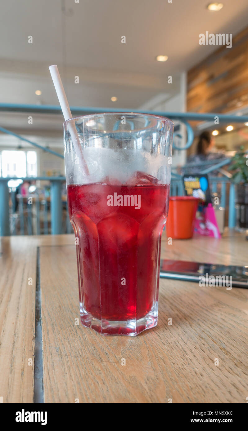 Ein Glas Eistee mit einem Papier Stroh in einer typisch englischen Cafe Stockfoto