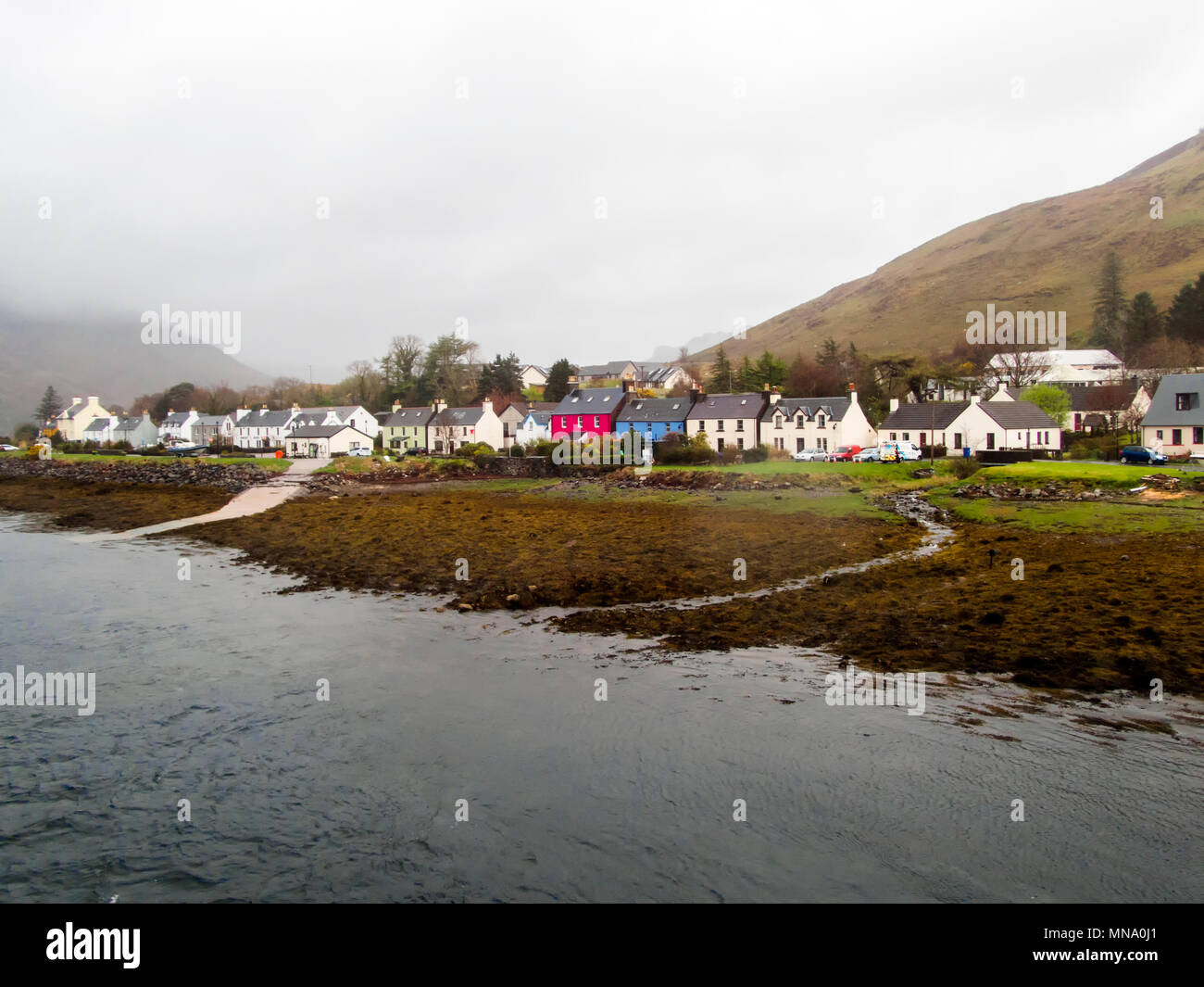 Schottische Szene im Regen und Nebel. Die schönen kleinen ehemaligen Fischerdorf Dornie am Ufer des Loch Duich und Loch Alsh mit seinen bunten h Stockfoto