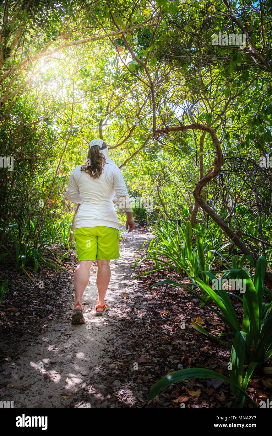 Frau gehen durch einen Wald auf einer kleinen Insel in der Karibik Stockfoto