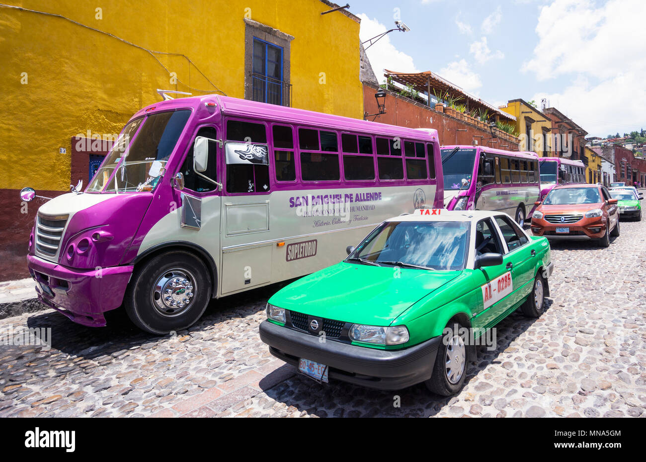 Verschiedene Formen der Verkehrsmittel in San Miguel de Allende, Mexiko: Taxi, Bus und Auto. Stockfoto