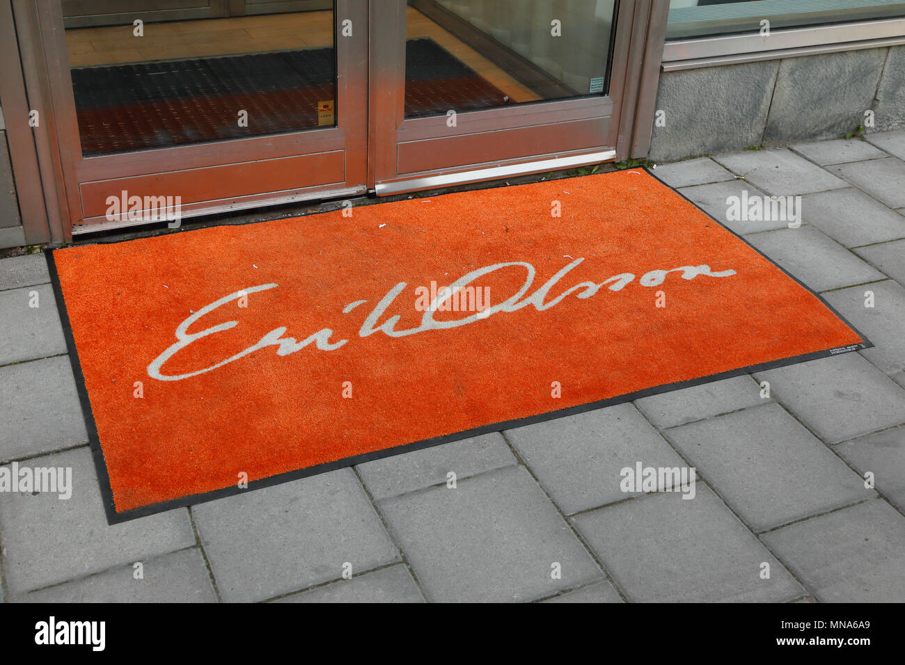 Stockholm, Schweden - 7. Juli 2016: Orange Teppich vor dem Eingang zum Immobilienmakler Erik Olsson's Büro an der Straße Sveavagen. Stockfoto