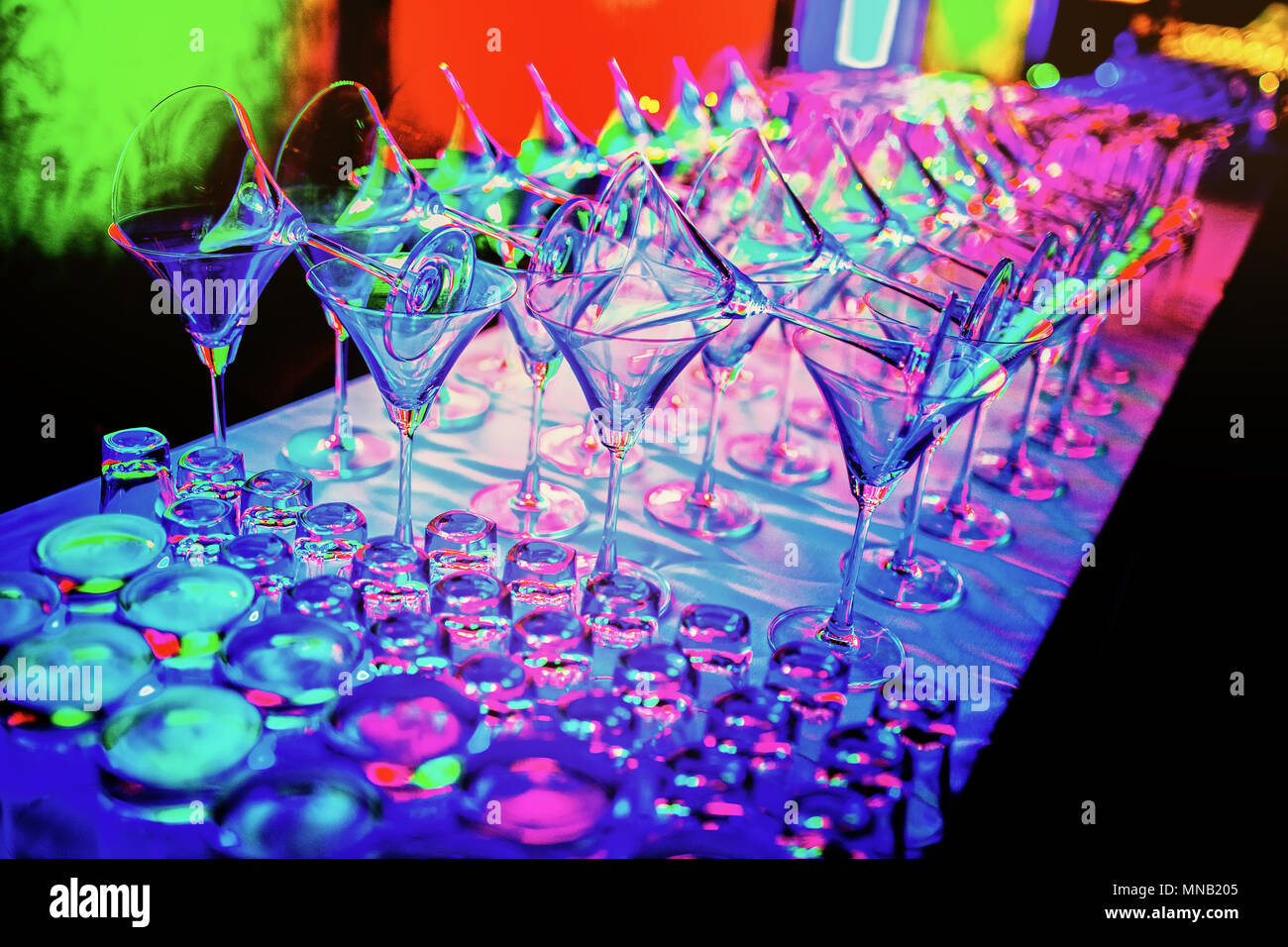Ein Bündel leer Weingläser Line Up auf der Theke mit Multi-color  LED-Reflexion über die Gläser in der Diskothek party Stockfotografie - Alamy