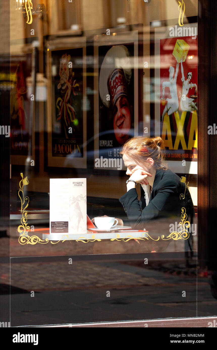 Eine junge blonde Frau im Herzlich Kuchen Cafe sitzen mit Ihrem Laptop und genießen eine Tasse Kaffee in Dundee city centre, VEREINIGTES KÖNIGREICH Stockfoto