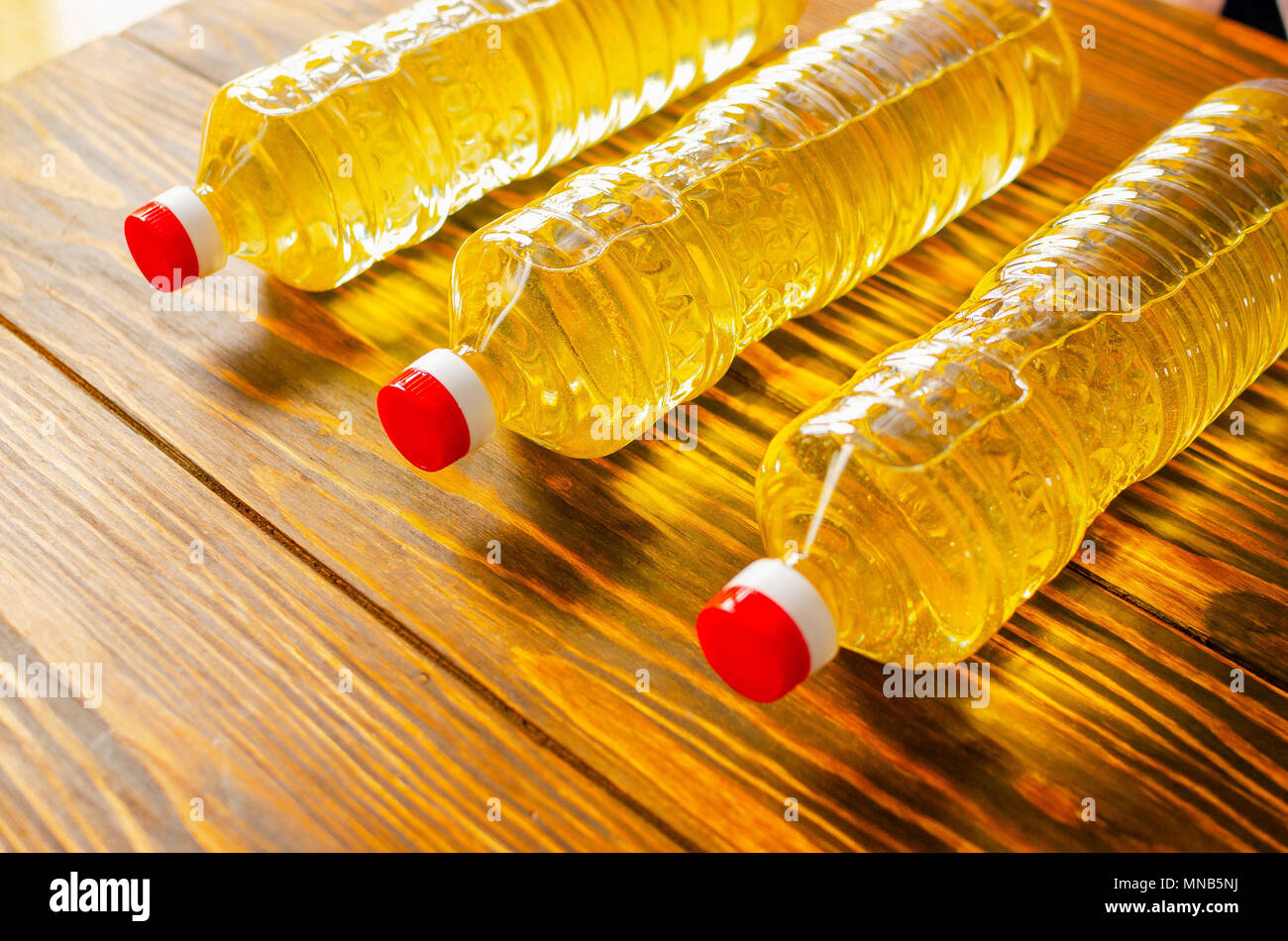 Sonnenblumenöl. Olivenöl. Flaschen mit Butter auf einem Holztisch. Stockfoto