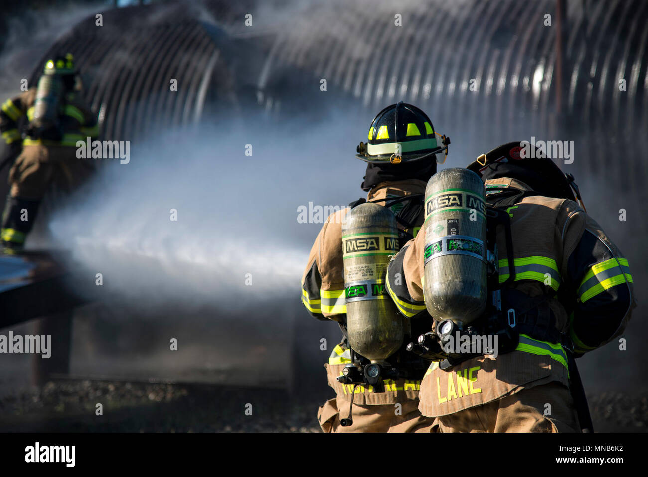 Senior Airman Justin Lane, rechts, und Staff Sgt. Tyler McFarland, 23d Bauingenieur Squadron (CES) Feuerwehrmänner, arbeiten zusammen, um ein Feuer auf einem Flugzeug Simulator während einer Live-Feuer zu löschen, Brennen, übung, 15. März 2018, bei Moody Air Force Base, Ga Feuerwehrmänner vom 23 d CES durchgeführt, um die Übung Flugzeuge Rettung Brandbekämpfung Fähigkeiten zu Führungspersönlichkeiten zu demonstrieren und Ehrenmitglieder Moody's Kommandanten. (U.S. Air Force Stockfoto