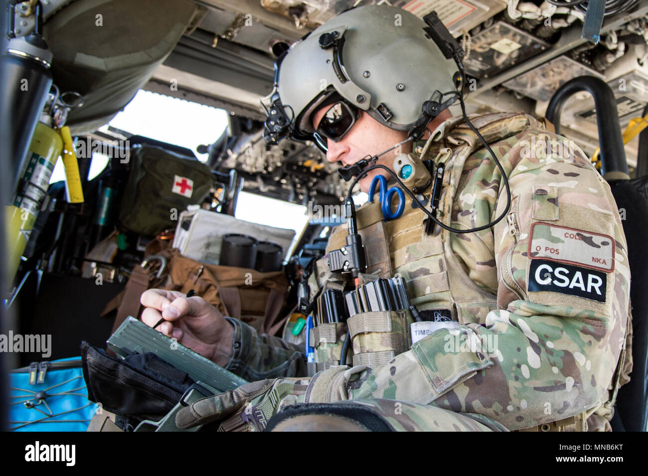 Tech Sgt. Justin Cole, 41 Rescue Squadron (RQS) spezielle Missionen aviator, nimmt Hinweise auf ein Radio Interface System, 15. März 2018, bei Moody Air Force Base, Ga Flieger vom 41. RQS und 723 d Aircraft Maintenance Squadron durchgeführt vor, um zu gewährleisten, dass ein HH-60G Pave Hawk war voll für eine simulierte Suche und Rettung Mission vorbereitet. (U.S. Air Force Stockfoto