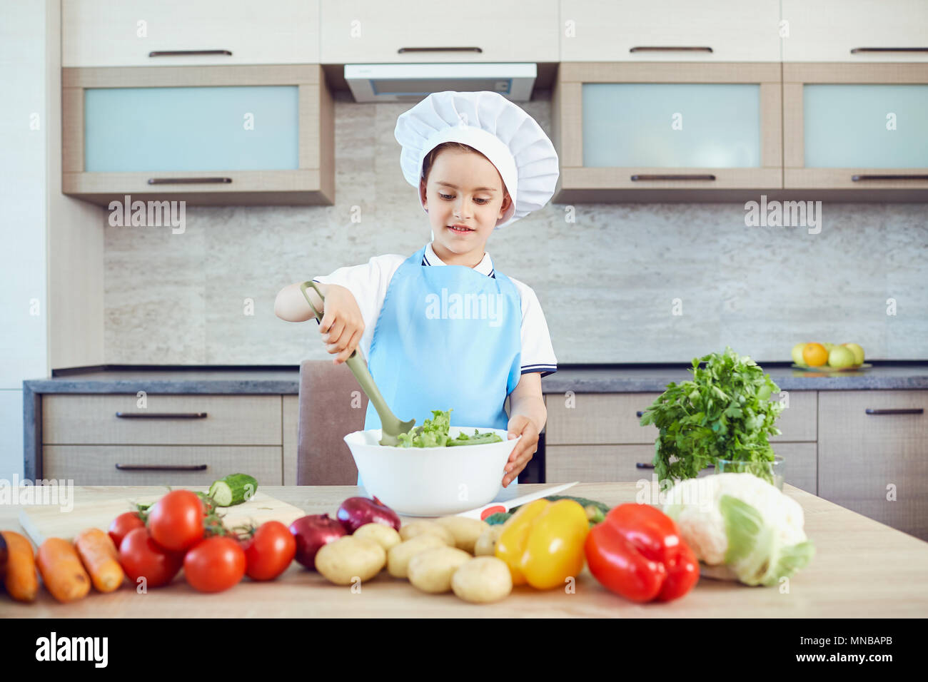 Ein Junge gekleidet als Koch Köche in der Küche Stockfoto
