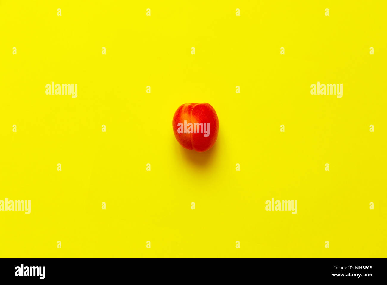 Lonely Aprikose isoliert über einen gelben Hintergrund von oben, flatlay Stil angesehen Stockfoto
