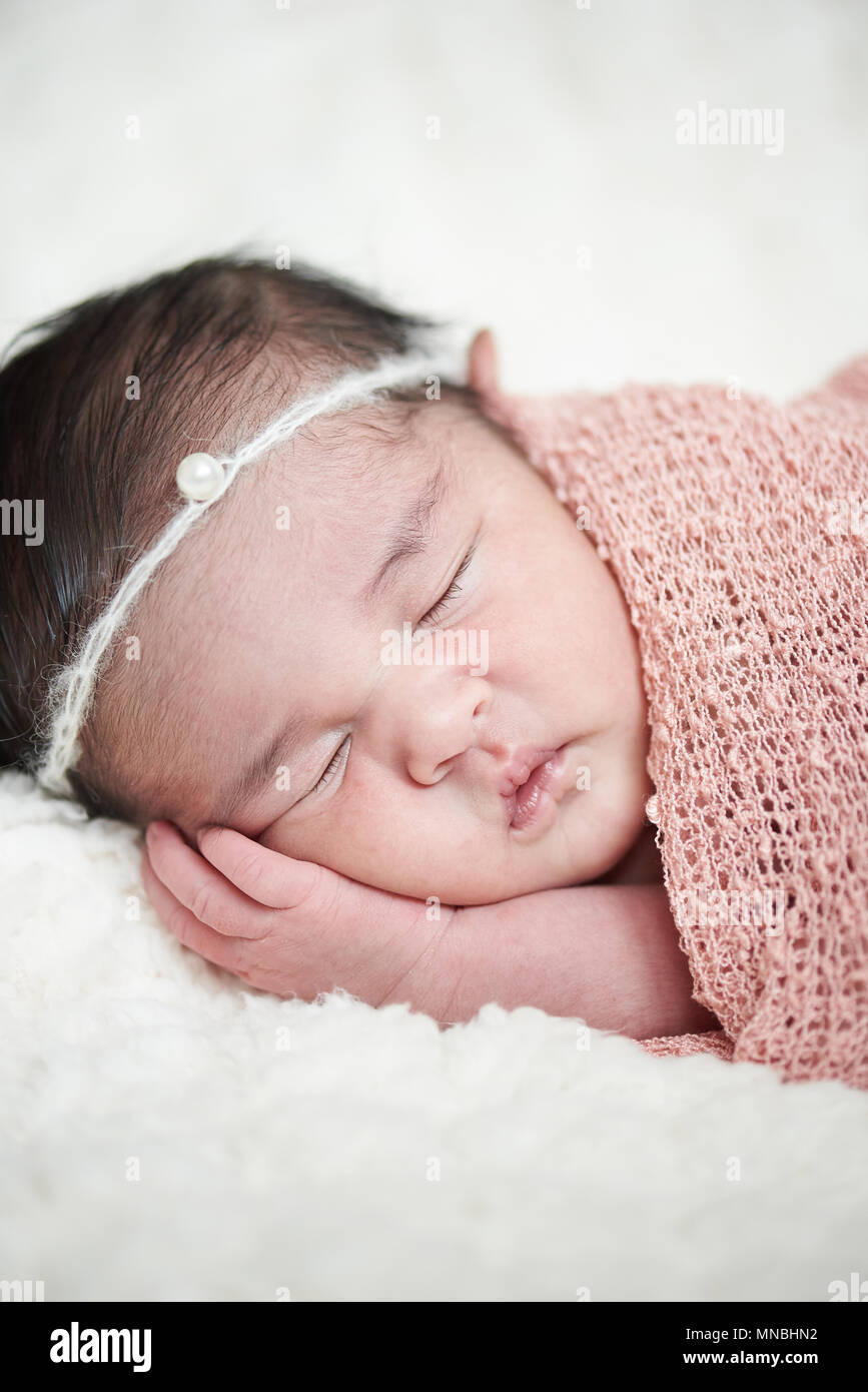 Ein neugeborenes Baby Mädchen schlafen auf weichen Kissen Stockfoto