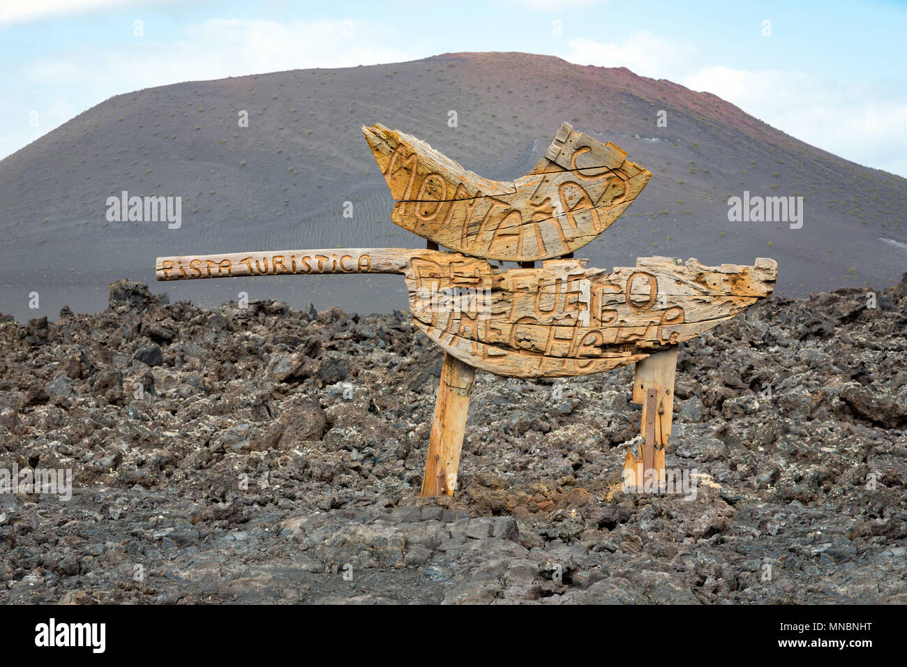 LANZAROTE, KANARISCHE INSELN, SPANIEN: hölzerne Wegweiser zum Feuer Berge am Eingang zum Nationalpark Timanfaya. Stockfoto