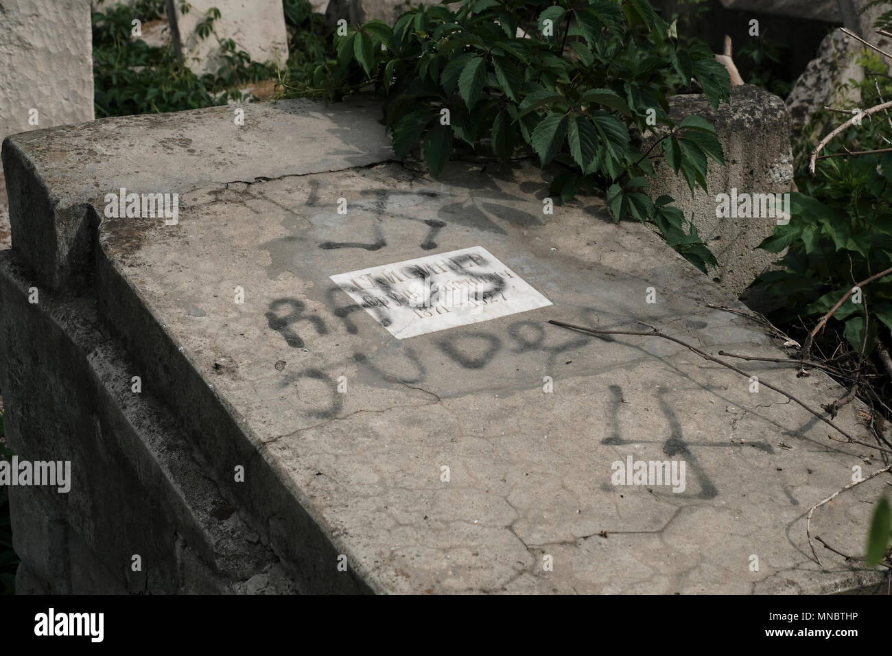 Ein entweihtes Grab mit Nazi-Hakenkreuz und einem Satz auf Deutsch „Raus Juden“ auf dem jüdischen Friedhof, einem der größten jüdischen Friedhöfe in Europa in der Stadt Chisinau, auch bekannt als die Hauptstadt der Republik Moldau Stockfoto