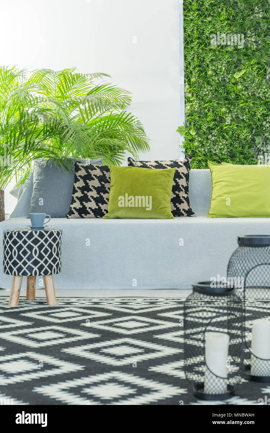 Helle, moderne Zimmer mit Sofa, Muster Zubehör und grünen Pflanzen Stockfoto