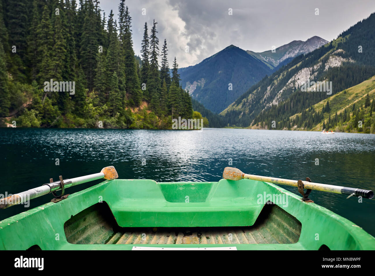 Schöne Sicht auf die Berge und den See Kolsai grüne Boot im Vordergrund in Kasachstan Stockfoto