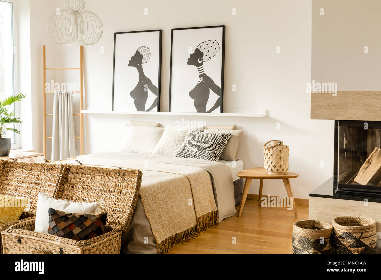 Holz- Tisch neben dem Bett mit Decke in warmen Schlafzimmer Innenraum mit  Plakaten und Leiter Stockfotografie - Alamy