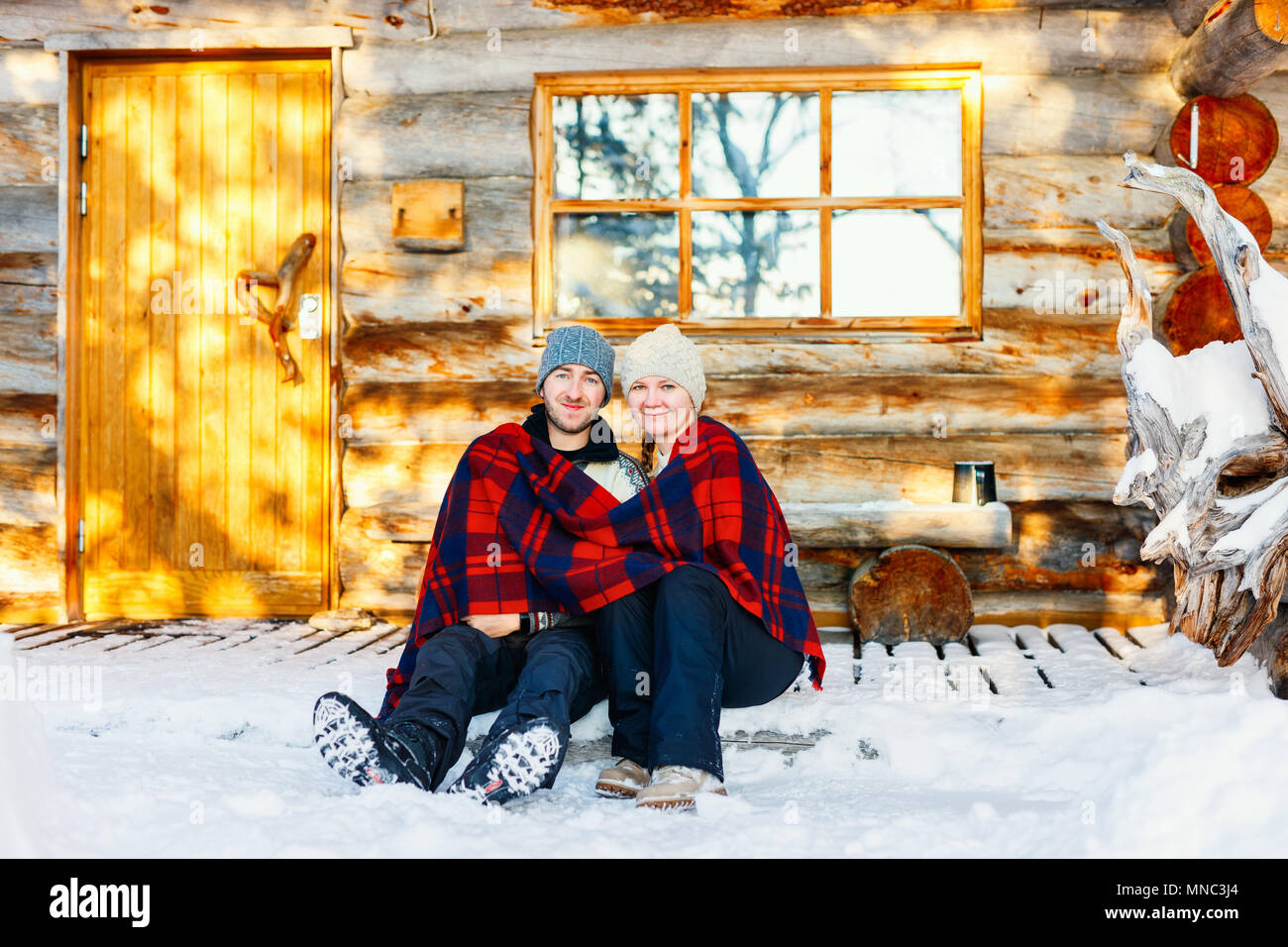 Paar im Freien auf der schönen Wintertag vor der Hütte Ferienhaus anmelden Stockfoto