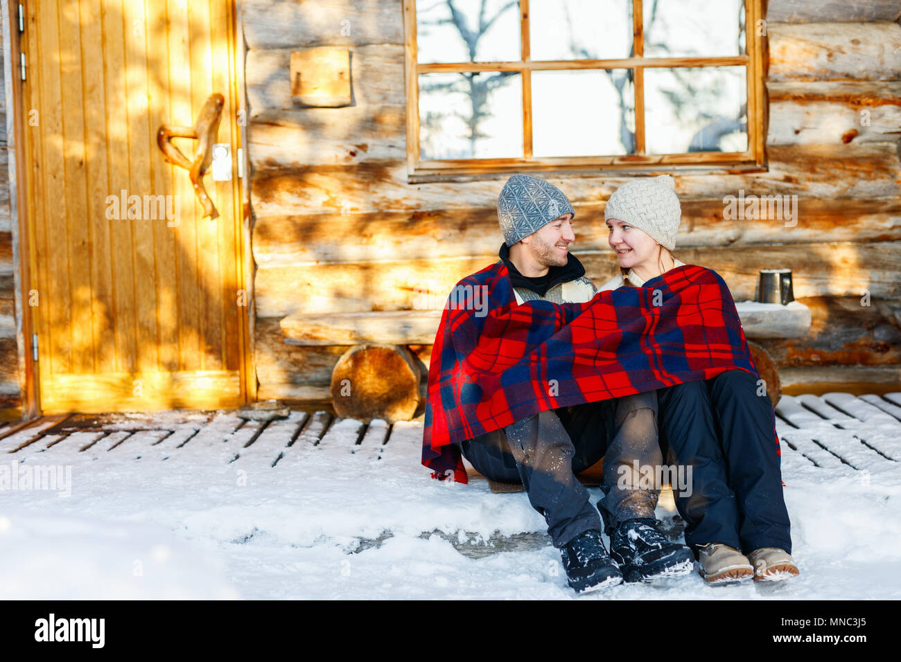 Paar im Freien auf der schönen Wintertag vor der Hütte Ferienhaus anmelden Stockfoto