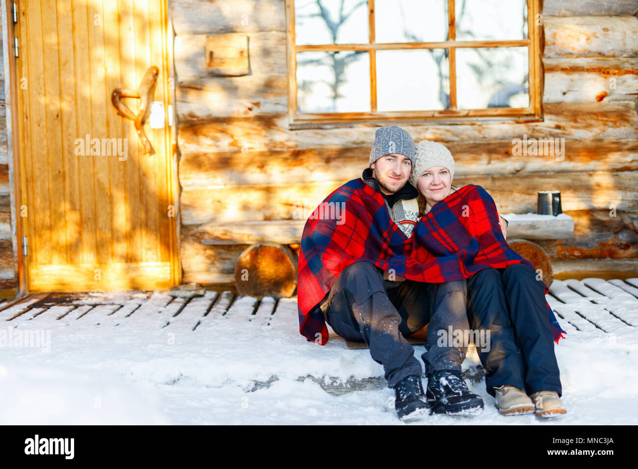 Paar im Freien auf der schönen Wintertag vor der Hütte Ferienhaus anmelden Stockfoto