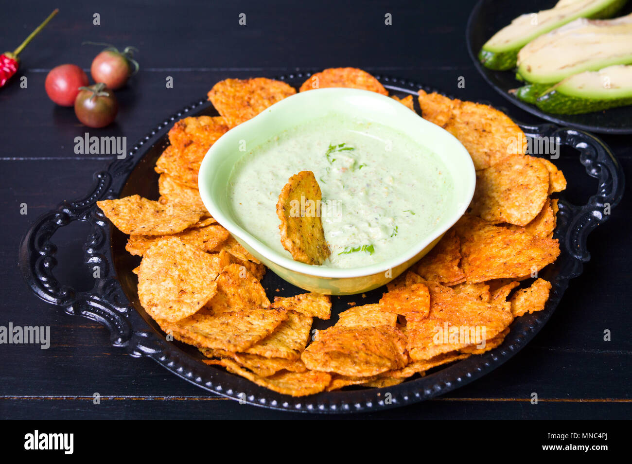 Tortilla Chips mit Avocado Dip serviert auf einem Teller Stockfoto