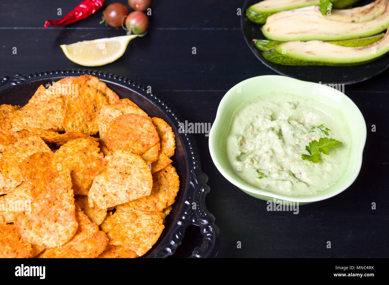Tortilla Chips mit Avocado Dip serviert auf einem Teller Stockfoto