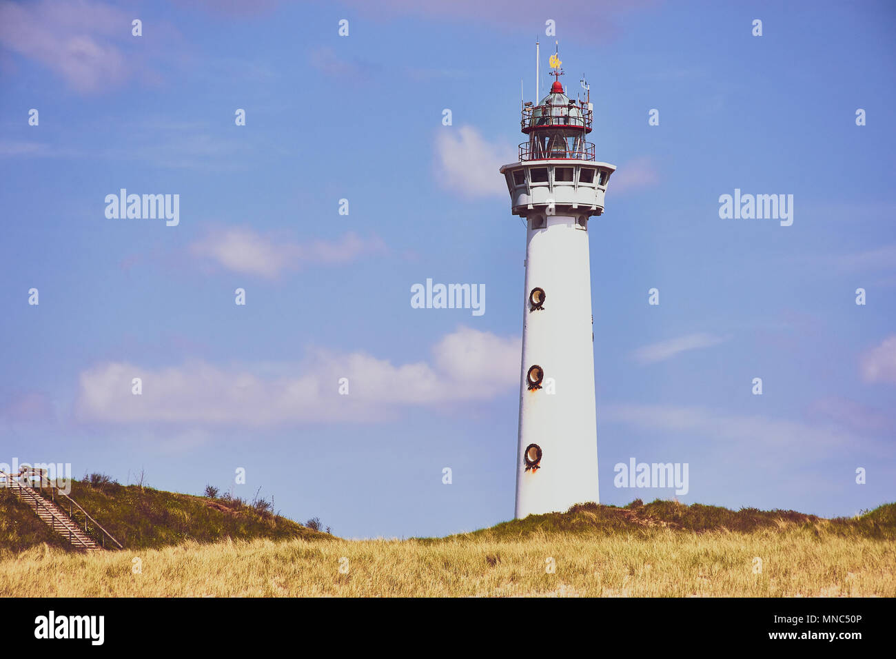 Weißen Leuchtturm in Egmond aan Zee, Niederlande, gegen den blauen bewölkten Himmel Stockfoto