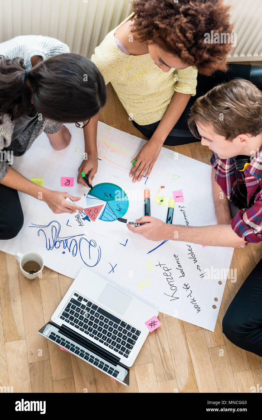 Drei Personen Beobachtungen schreiben während des Brainstorming Stockfoto