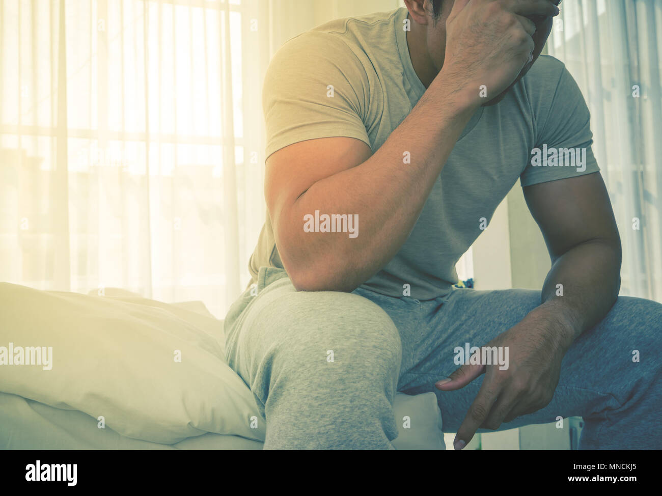 Mann im Schlafanzug ist Kopfschmerzen im Bett von Hängen über Stress am Morgen und Stockfoto