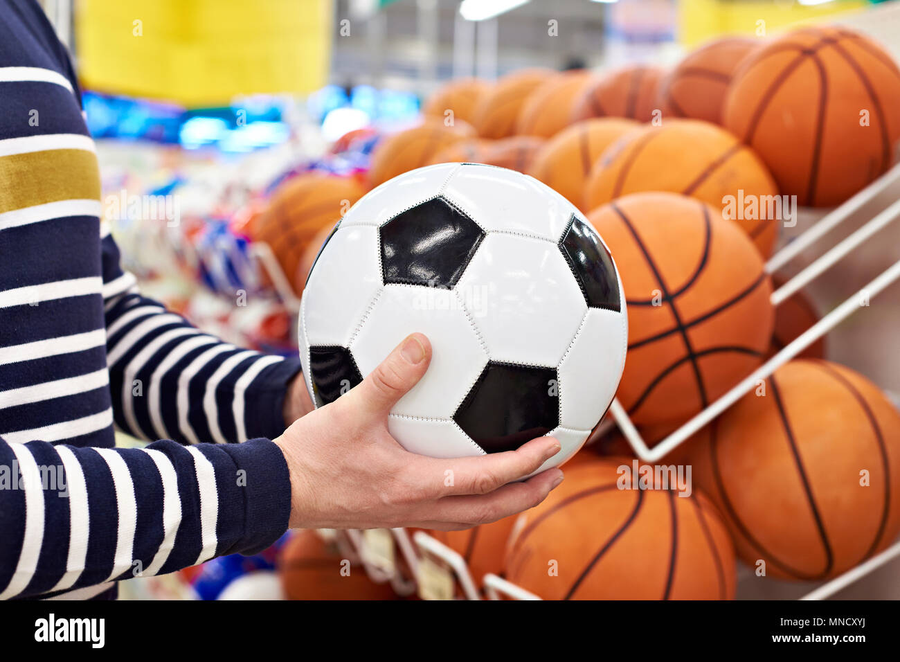 Buyer's Hände mit Fußball und Basketball in der Sport Shop Stockfoto