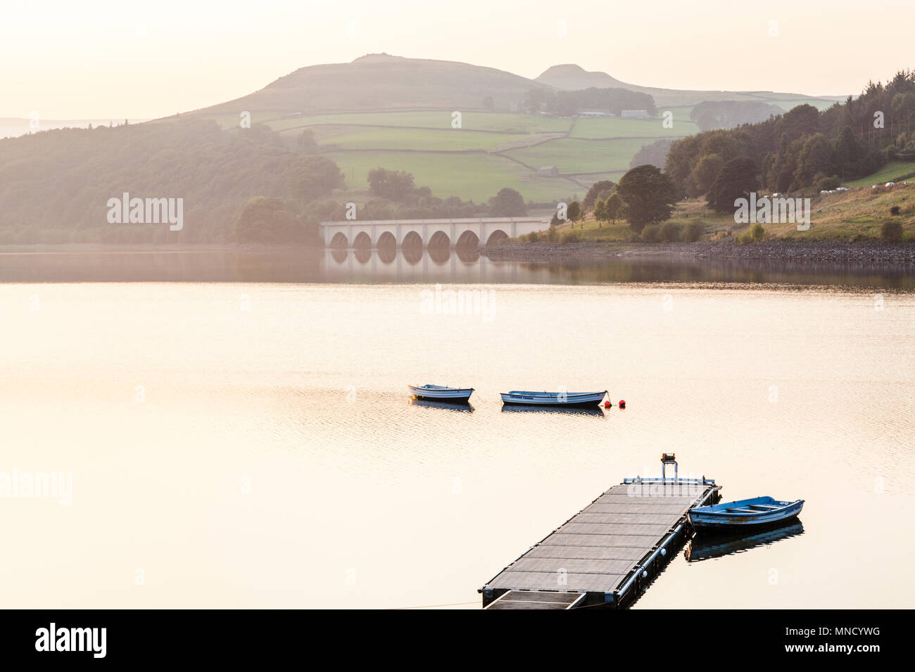 Boote auf Ladybower Reservoir an einem Herbstabend. Darüber hinaus sind Ashopton Viadukt und Krummstab Hill, Derbyshire, Peak District, England, Großbritannien Stockfoto