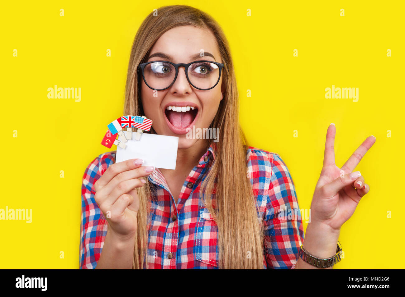 Junge Frau mit Karte und Flaggen verschiedener Länder. Studio Portrait der jungen schönen weiblichen Kursteilnehmer Stockfoto