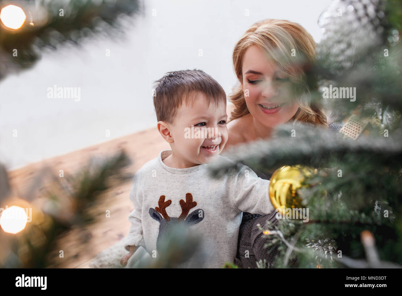 Hohe Betrachtungswinkel und fröhliche Dekoration Weihnachtsbaum mit Mutter zu Hause Stockfoto