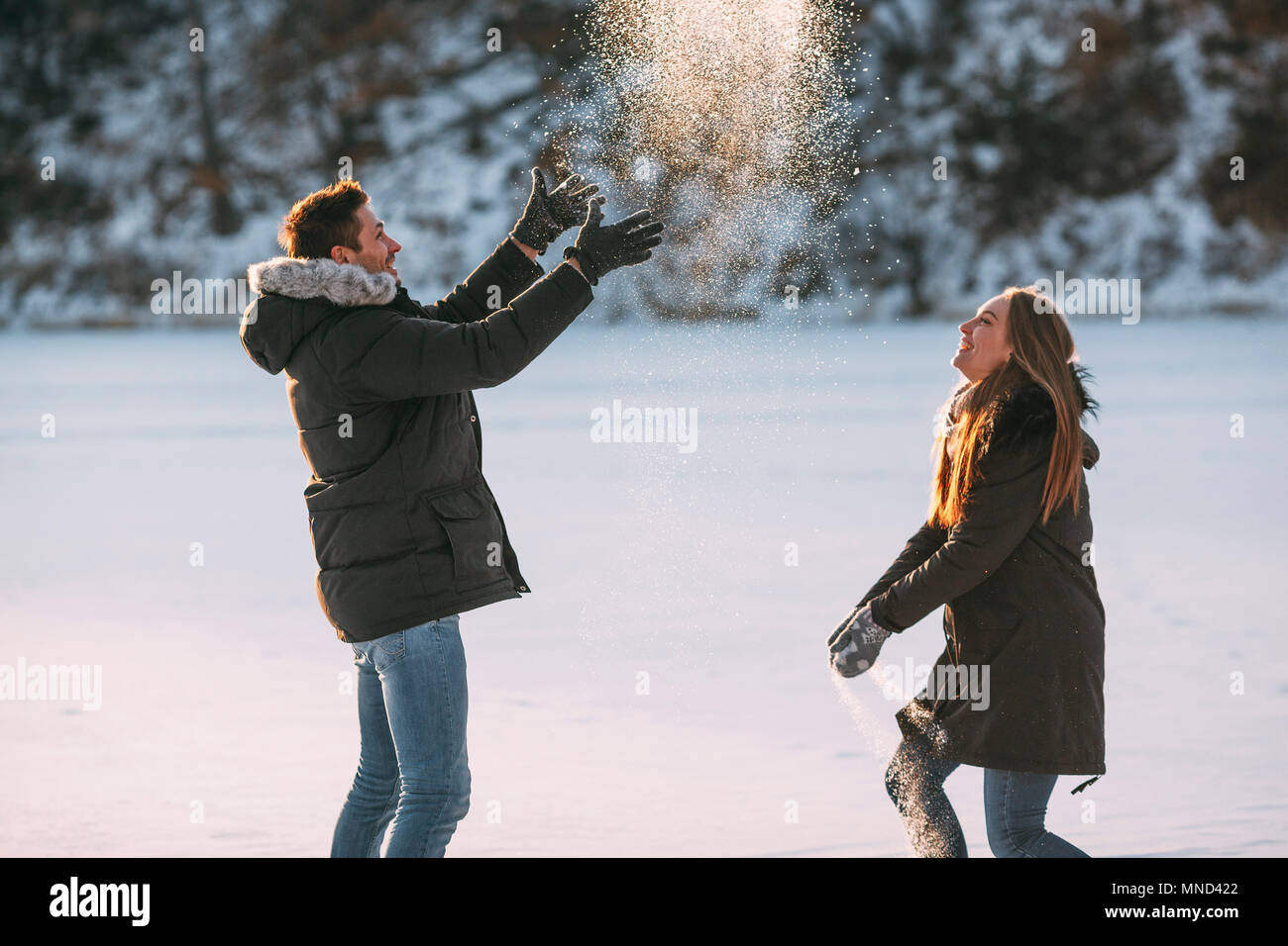Seitenansicht des verspielten Paar beim im Schnee Stockfoto
