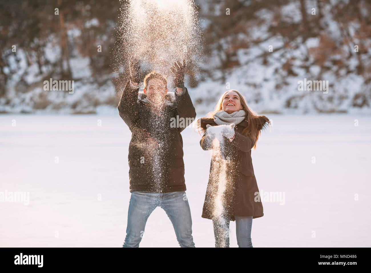 Verspieltes Paar werfen Schnee Stockfoto