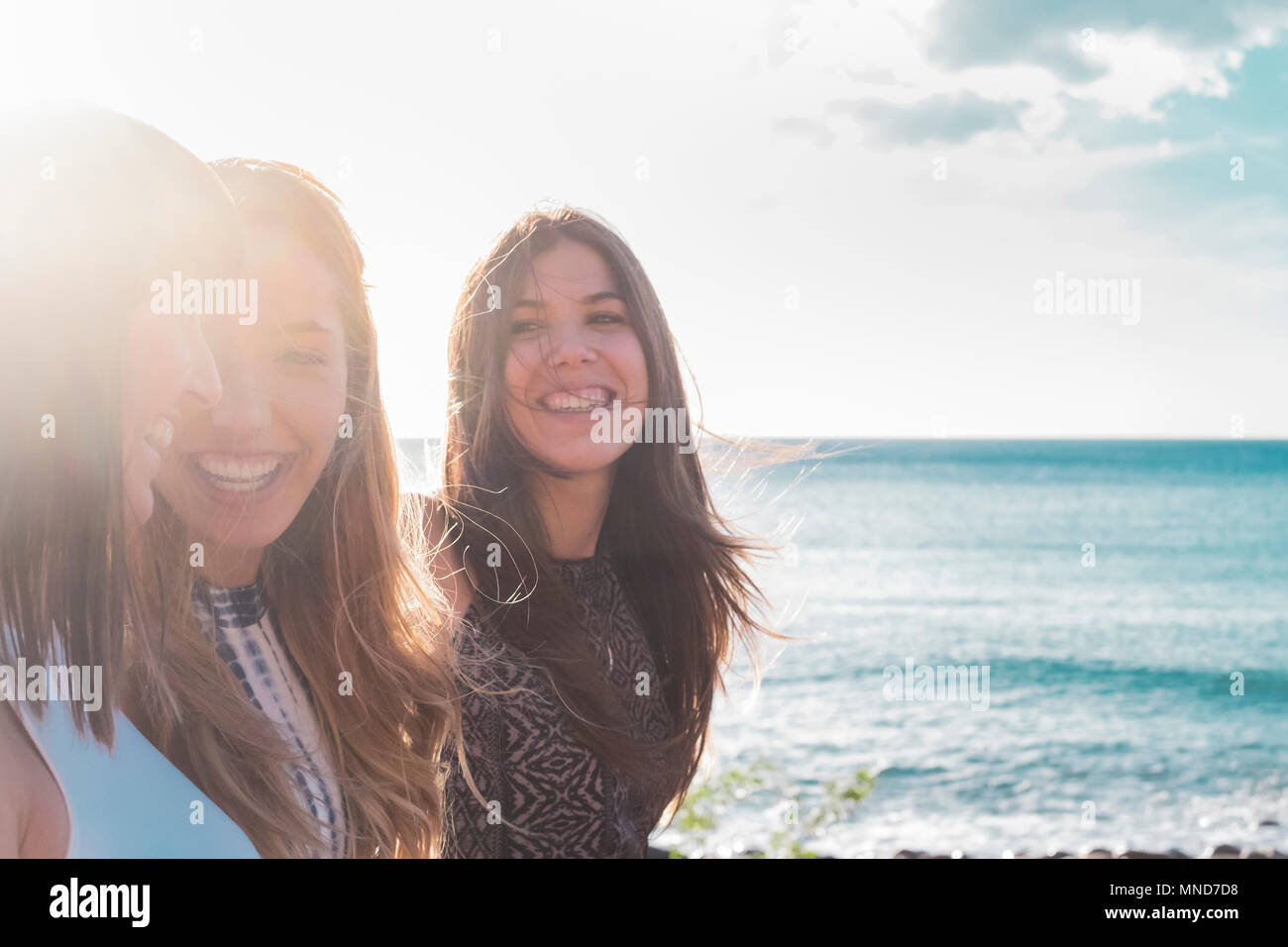 3 Junge Frauen am Strand spazieren gehen, sich gegenseitig suchen, Lachen und freie Zeit zusammen verbringen. an einem schönen Sommertag. mit Sonne und Meer als backgroun Stockfoto