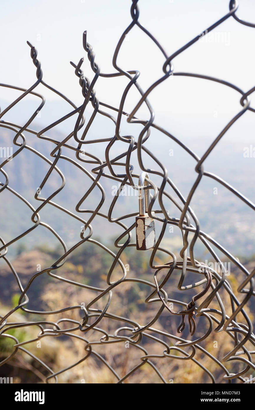 Vorhängeschloss auf beschädigte chainlink Fence gegen Sky Stockfoto
