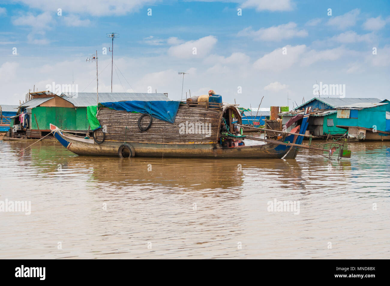 Eine sampan - wie Boot, einschließlich ein kleines Tierheim mit einem geschwungenen Dach aus Holz und Stroh, dass eine dauerhafte Behausung in Chong Kneas sein könnte. Stockfoto