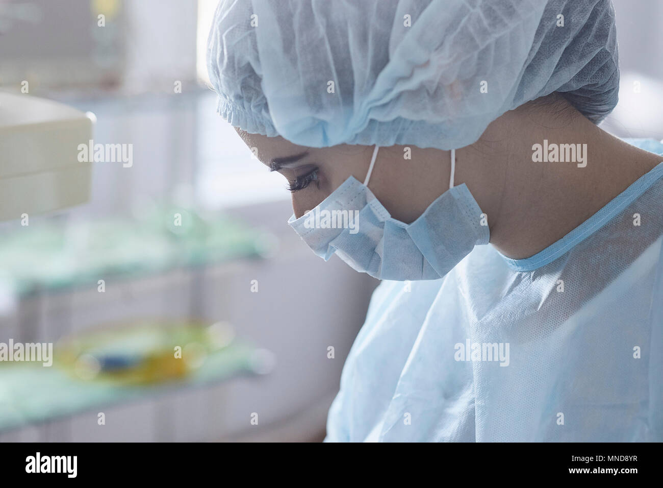 Nahaufnahme der Chirurg das Tragen von Mundschutz und der Kappe an Operationssaal arbeiten Stockfoto