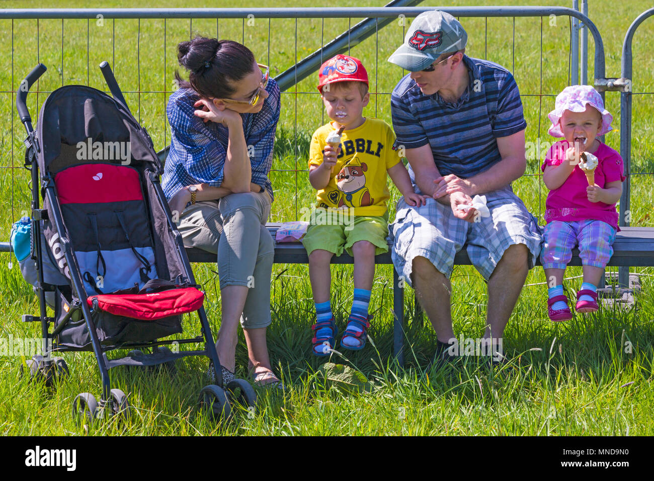 Familie sitzt mit Kinder essen Eis im Hampshire Spiel & Country Fair, netley Marsh, Hampshire Großbritannien im Mai Stockfoto