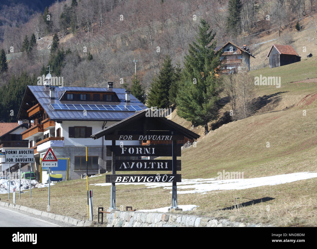 Schild, die den Anfang einer italienischen Dorf namens Forni Avoltri. Das Wort bedeutet Benvegnuz Willkommen im Dialekt Italienisch Stockfoto