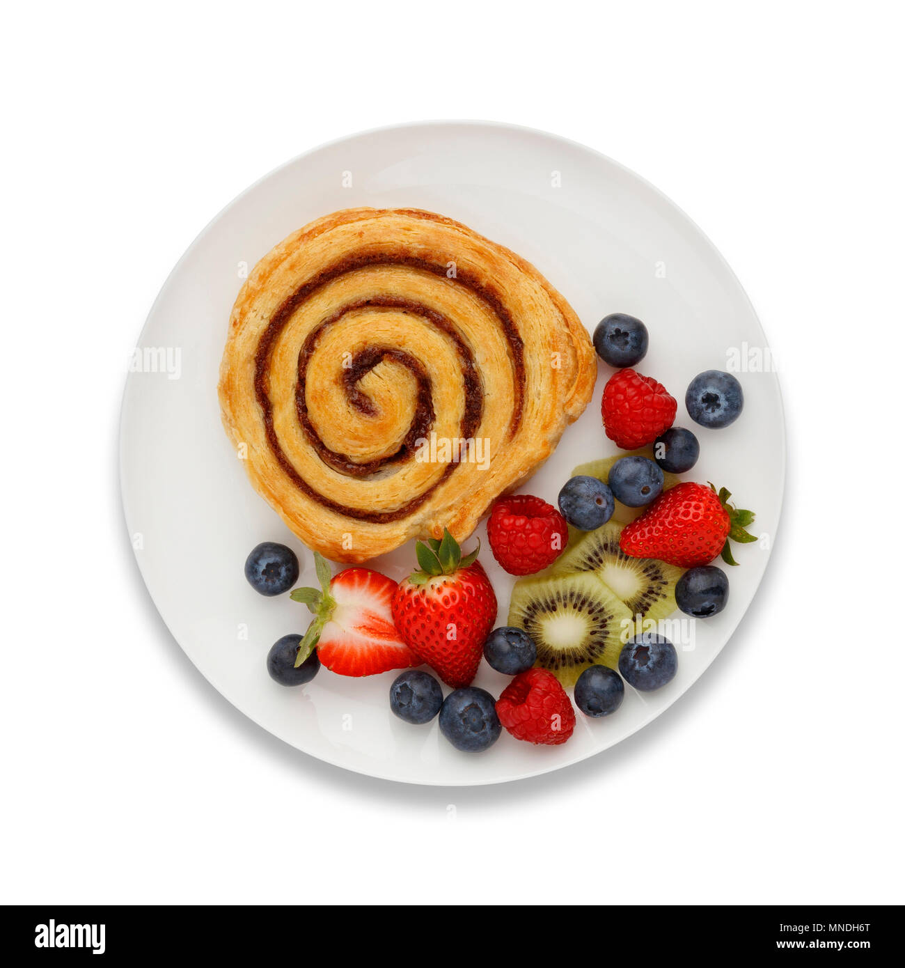 Cinnamon Swirl und Obst auf einer weißen Platte, mit einem Schlagschatten, Schuß von oben. Stockfoto
