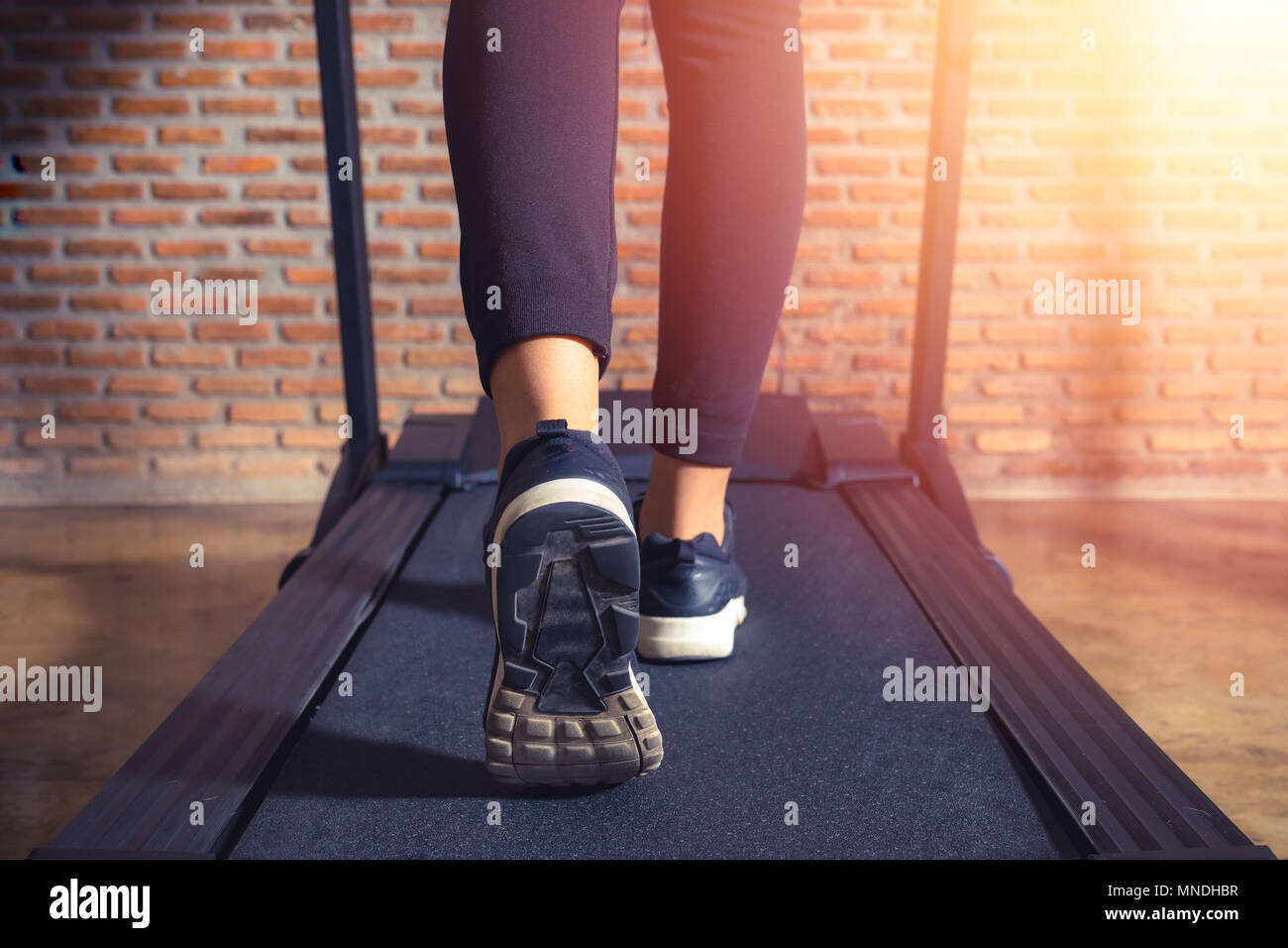 Nahaufnahme auf shoe Athlet, der Frau, die in einer Turnhalle auf einem Laufband. Training und Sonnenlicht Wirkung, Fitness und gesunde Lebensweise Stockfoto