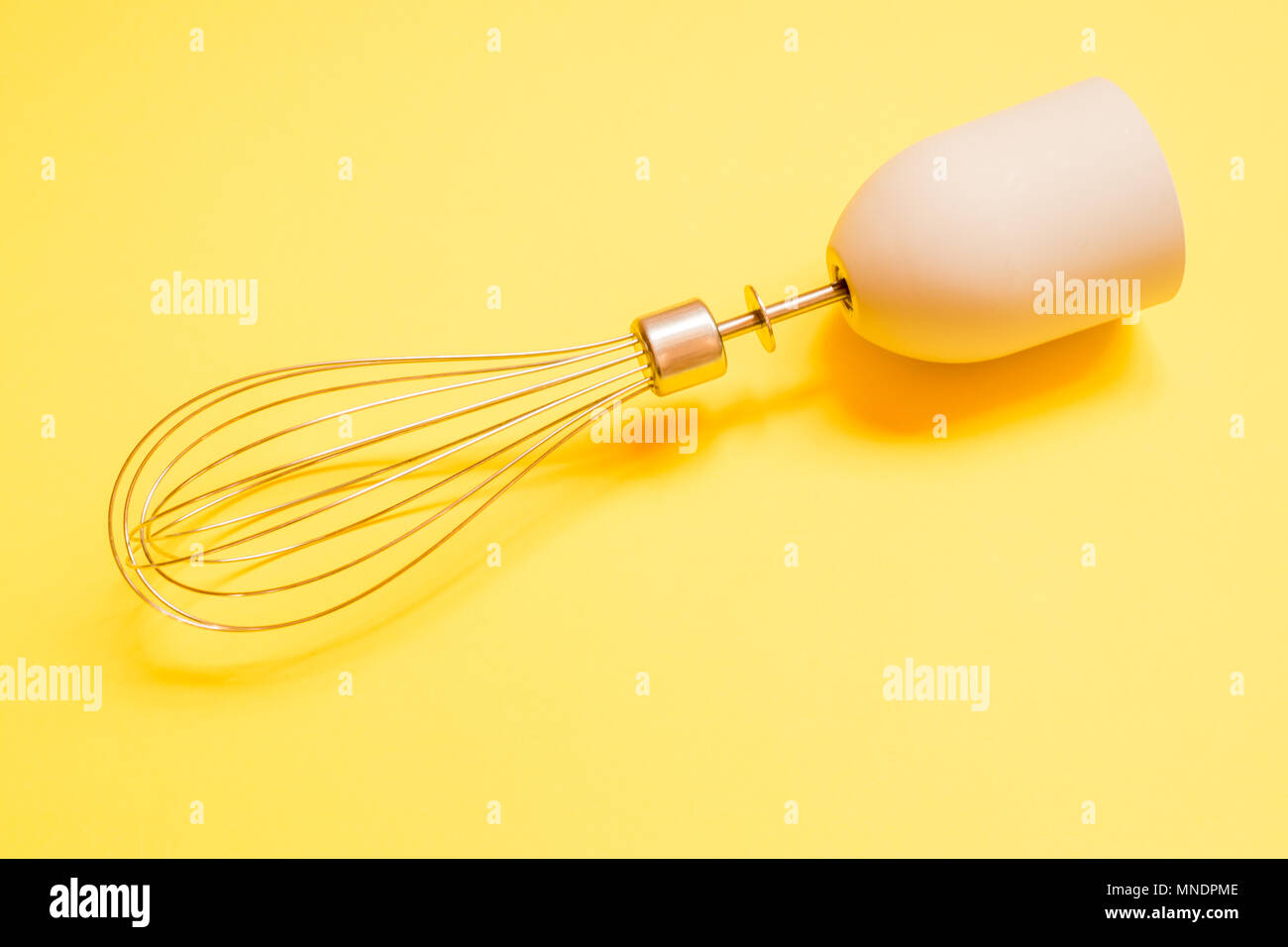 Edelstahl ballon Schneebesen auf gelben Hintergrund. Stockfoto