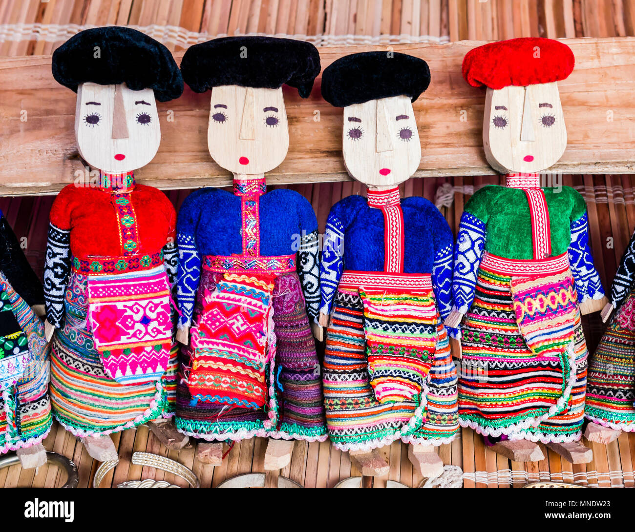Reihe von schwarzen und roten Dzao Puppen aus Holz in traditioneller Kleidung, können Cau Markt, Northern Vietnam Stockfoto