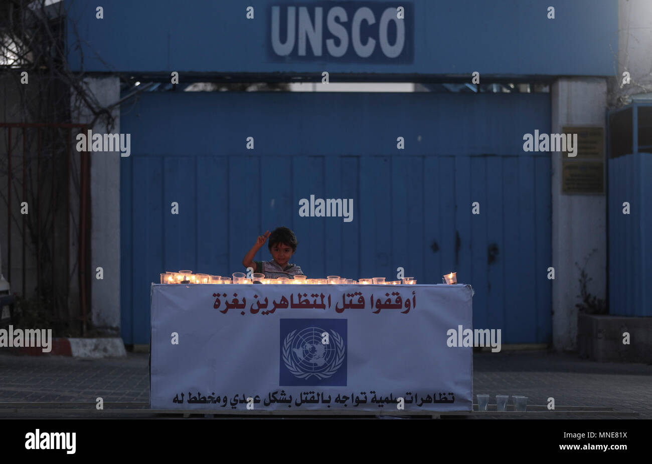 Ein palästinensischer Junge steht hinter Kerzen während einer Mahnwache für die Opfer der Israel-Gaza Zusammenstößen an der Grenze, an der Pforte des UN-Sonderkoordinators für den Nahost-friedensprozess (UNSCO) in Gaza, Gazastreifen, 16. Mai 2018. Mehr als 60 Palästinenser getötet und etwa 2.400 während der massenproteste entlang der Grenze auf der 70. Jahrestag der Nakba Tag (Tag der Katastrophe), die die Vertreibung vor und der Israelischen Unabhängigkeitserklärung 1948 folgte Marken verletzt wurden. Foto: Wissam Nassar/dpa Stockfoto
