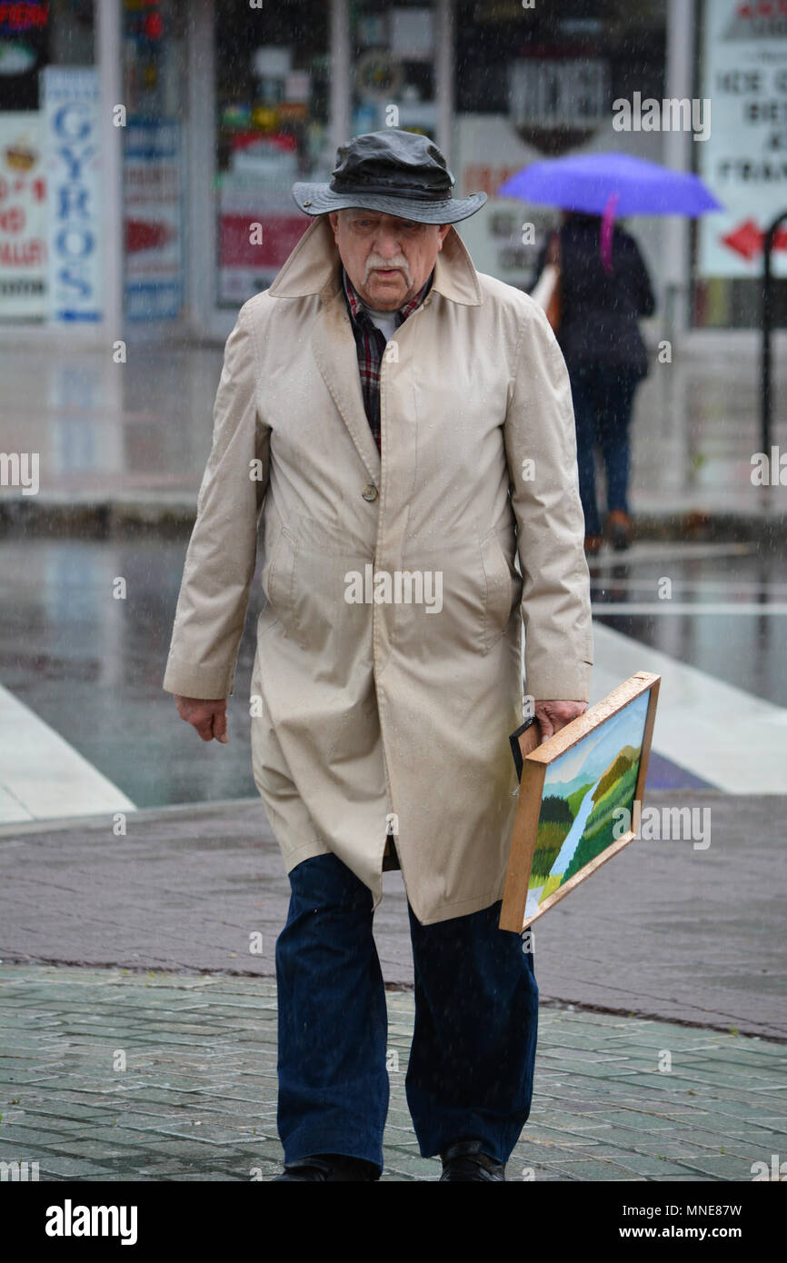 Wilkes Barre, USA. 16. Mai 2018. Am Tag vor der bildenden Künste Fiesta ist geplant in Wilkes Barre PA zu öffnen, 83 Jahre alten Künstler Frank Kluk seine Weise slogs durch die sintflutartigen Regenfälle auf dem Weg nach Wyoming Valley kunst-Liga zelt Monsun wie Wetter wurde Plagen, N. E. PA. Für die in der vergangenen Woche zu Überschwemmungen von kleinen Bächen. Aussteller und Künstler sind in der Hoffnung auf eine Pause in der anhaltenden Wetter Muster als Datum für die Eröffnung der Open Air Fiesta ist weniger als 24 Std. entfernt. der Bildenden Kunst Fiesta, eine Feier der darstellenden und bildenden Künste, ist 63 Jahre alt, im Jahr 2018 die meisten etablierten Festival Stockfoto