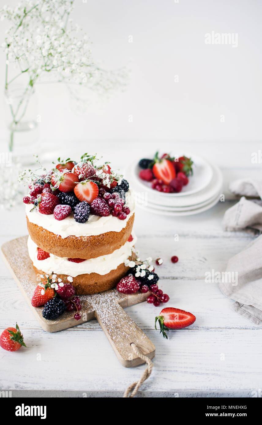 Mittsommer Schicht Kuchen mit Schlagsahne und Beeren Stockfoto