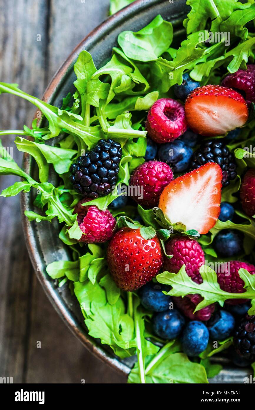 Grüner Salat mit Rucola und Beeren Stockfoto